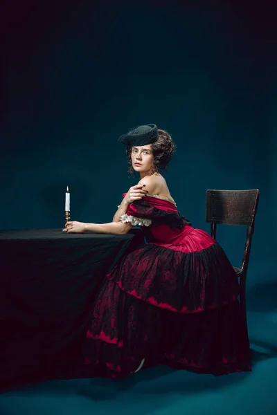Young woman as Anna Karenina on dark blue background. Retro style, comparison of eras concept. — Stock Photo, Image