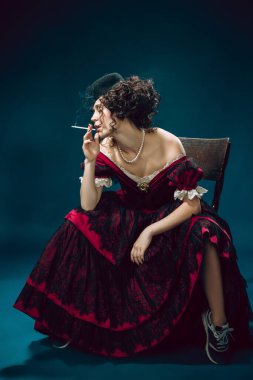 Koyu mavi arka planda Anna Karenina gibi genç bir kadın. Retro biçimi, dönemin karşılaştırması.