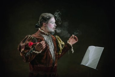 Johann Sebastian Bach gibi genç bir adam koyu yeşil arka planda. Retro biçimi, dönemin karşılaştırması.