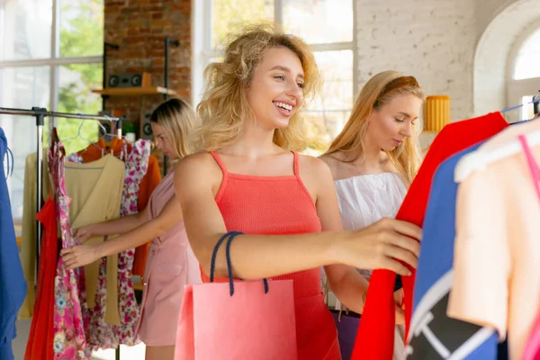 Draag, kleding winkel tijdens de verkoop, zomer of herfst collectie. Jonge vrouwen op zoek naar nieuwe kleding — Stockfoto