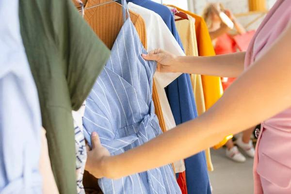 Draag, kleding winkel tijdens de verkoop, zomer of herfst collectie. Jonge vrouwen op zoek naar nieuwe kleding — Stockfoto