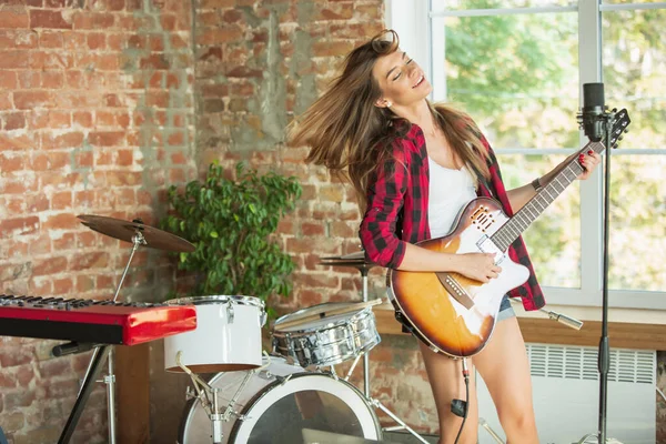 Vrouw in hoofdtelefoon die muziek opneemt, zingt of internetles geeft terwijl ze op zolder of thuis zit — Stockfoto