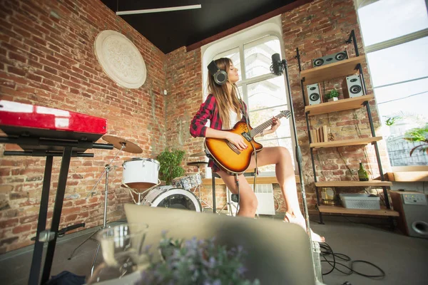 Vrouw in hoofdtelefoon die muziek opneemt, zingt of internetles geeft terwijl ze op zolder of thuis zit — Stockfoto