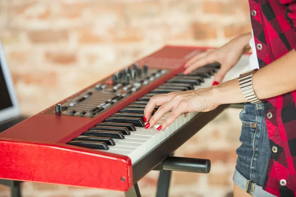 Mujer grabando música, cantando y tocando el piano mientras está de pie en el lugar de trabajo o en casa —  Fotos de Stock