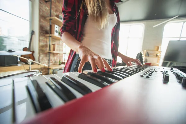 Mujer grabando música, cantando y tocando el piano mientras está de pie en el lugar de trabajo o en casa — Foto de Stock