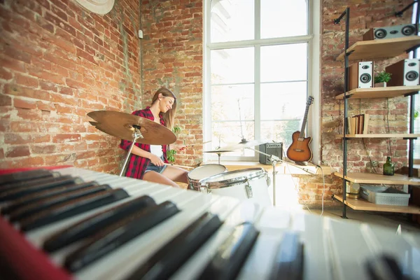 Vrouw die muziek opneemt, zingt en drumt terwijl ze op zolder of thuis zit — Stockfoto