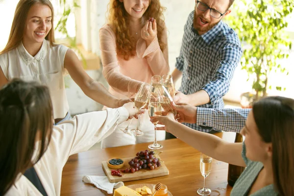 Gente tintineando vasos con vino o champán. Felices amigos alegres celebran las fiestas, reunión. Primer plano de amigos sonrientes, estilo de vida — Foto de Stock