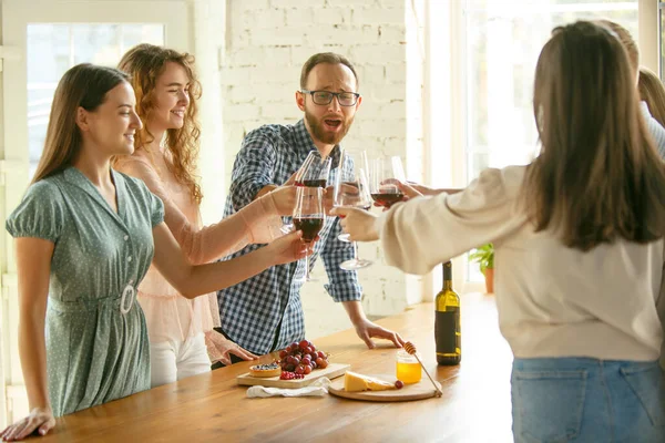 Folk klinkar glas med vin eller champagne. Glada glada vänner firar högtider, möte. Närbild bild av leende vänner, livsstil — Stockfoto