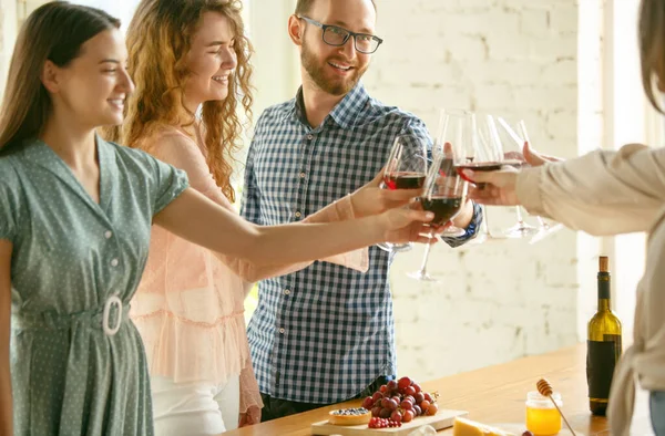 Lidé cinkají sklenicemi s vínem nebo šampaňským. Šťastní veselí přátelé slaví svátky, setkání. Detailní záběr usmívající se přátelé, životní styl — Stock fotografie