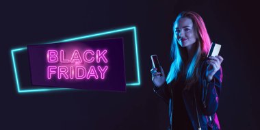 Karanlık arka planda neon ışıklı genç bir kadının portresi. İnsan duyguları, Kara Cuma, siber pazartesi, alışverişler, satışlar, finans konsepti. Neoned harfleri..