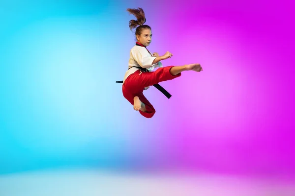 Karatê, menina taekwondo com cinto preto isolado no fundo gradiente em luz de néon — Fotografia de Stock