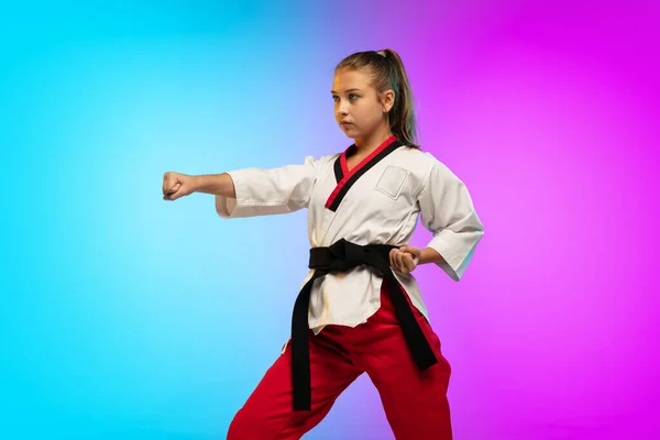 Karate, taekwondo flicka med svart bälte isolerad på lutning bakgrund i neon ljus — Stockfoto