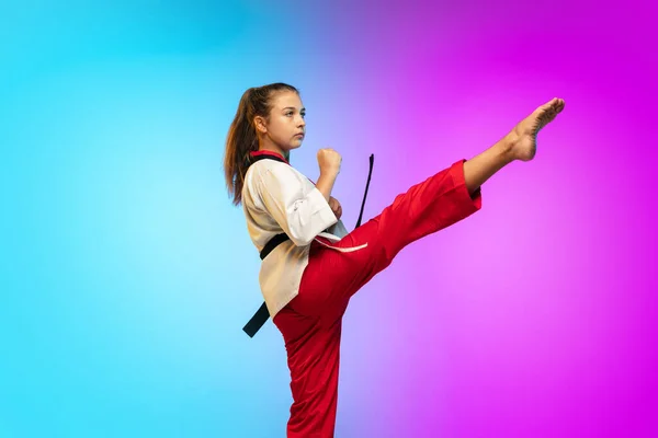 Karatê, menina taekwondo com cinto preto isolado no fundo gradiente em luz de néon — Fotografia de Stock