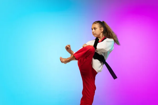 Karatê, menina taekwondo com cinto preto isolado no fundo gradiente em luz de néon — Fotografia de Stock