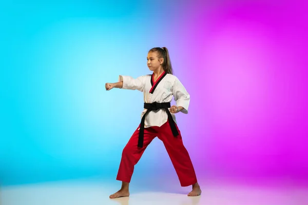 Karate, chica taekwondo con cinturón negro aislado sobre fondo degradado en luz de neón — Foto de Stock