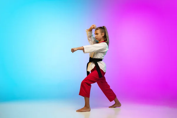 Karate, taekwondo girl with black belt isolated on gradient background in neon light — Stock Photo, Image