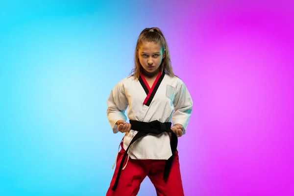 Karatê, menina taekwondo com cinto preto isolado no fundo gradiente em luz de néon — Fotografia de Stock