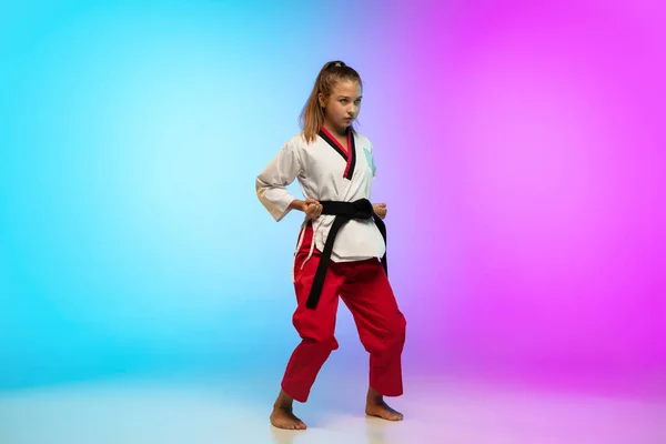 Karatê, menina taekwondo com cinto preto isolado no fundo gradiente em luz de néon — Fotografia de Stock