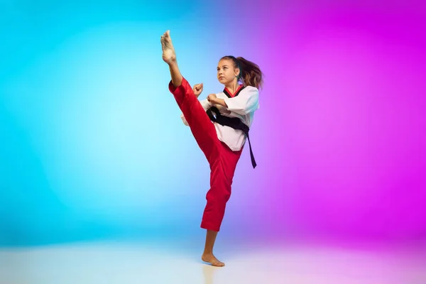 Karatê, menina taekwondo com cinto preto isolado no fundo gradiente em luz de néon — Fotografia de Stock