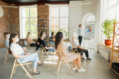 Erkek konuşmacı, üniversite atölyesinde sunum yapıyor. Seyirci ya da konferans salonu