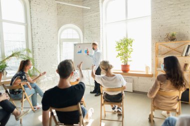 Erkek konuşmacı, üniversite atölyesinde sunum yapıyor. Seyirci ya da konferans salonu