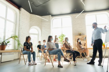 Erkek konuşmacı, üniversite atölyesinde sunum yapıyor. Seyirci ya da konferans salonu