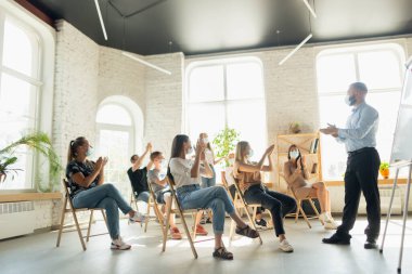 Erkek konuşmacı, üniversite atölyesinde sunum yapıyor. Seyirci ya da konferans salonu