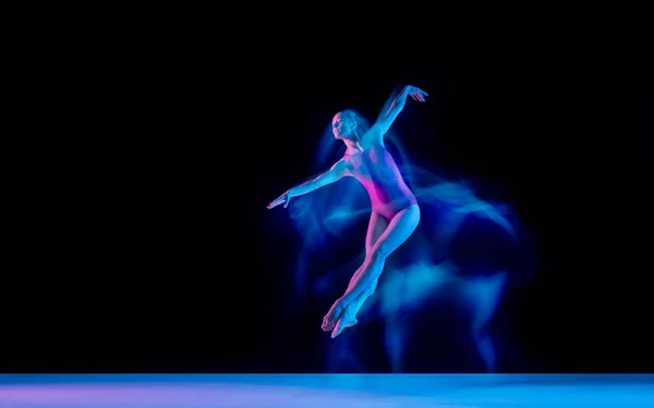 Νεαρή και χαριτωμένη χορεύτρια μπαλέτου απομονωμένη σε μαύρο φόντο στούντιο σε νέον μικτό φως — Φωτογραφία Αρχείου