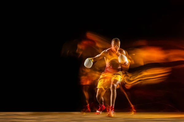 Professionell boxerträning isolerad på svart studio bakgrund i blandat ljus — Stockfoto