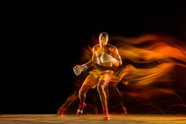 Profesionální boxer školení izolované na černém pozadí studia ve smíšeném světle — Stock fotografie