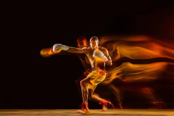 Entraînement de boxeur professionnel isolé sur fond de studio noir en lumière mixte — Photo