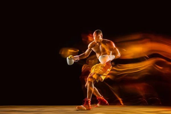 Professionelles Boxtraining isoliert auf schwarzem Studiohintergrund in gemischtem Licht — Stockfoto