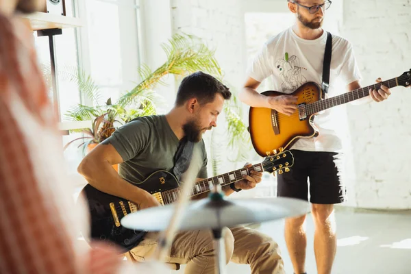 Musician band jamming together in art workplace with instruments