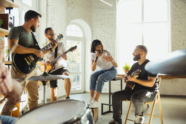 Musician band jamming together in art workplace with instruments