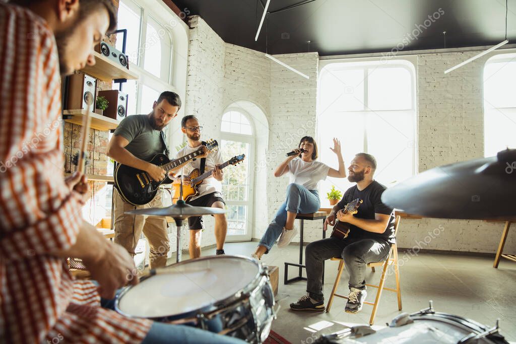 Musician band jamming together in art workplace with instruments