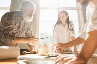 Erkek mimar-mühendis, genç aile için müstakbel ev projesini sunar..