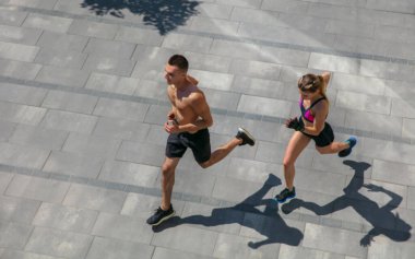 Spor kıyafetli genç bir çift sabah sporu yapıyor, dışarıda spor yapıyor, sağlıklı bir yaşam tarzı var.