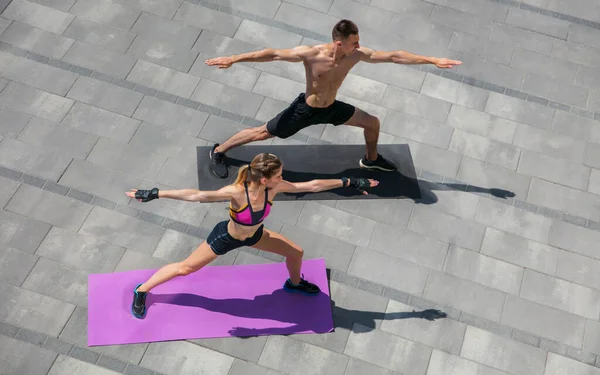 Pareja joven en traje deportivo haciendo ejercicio matutino al aire libre, estilo de vida saludable — Foto de Stock