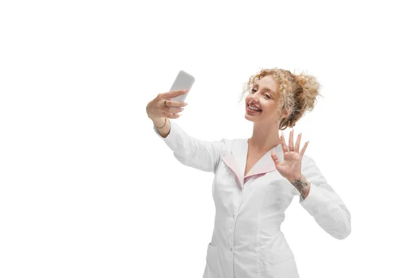 Portrait de femme médecin, infirmière ou cosmétologue en uniforme blanc et gants bleus sur fond blanc — Photo