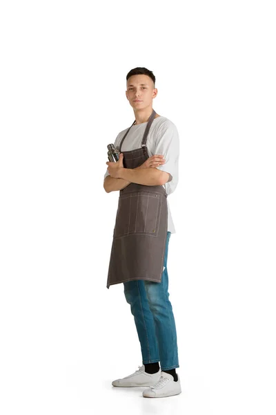 Retrato aislado de un joven camarero caucásico o camarero en delantal marrón sonriendo — Foto de Stock