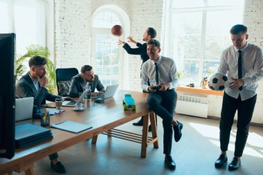 Mesai arkadaşları sıkı çalışırken iş arkadaşları ofiste eğleniyor.