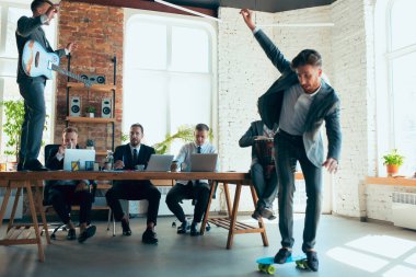 Mesai arkadaşları sıkı çalışırken iş arkadaşları ofiste eğleniyor.