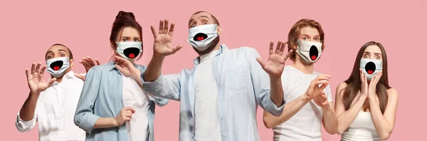 Grupp av skrämda människor, kvinnor och män bär skyddande ansiktsmask på rosa korall bakgrund — Stockfoto