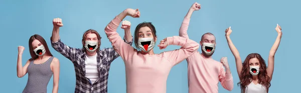 Csoport megdöbbent, boldog emberek, nők és férfiak visel védő arc maszk kék háttér — Stock Fotó