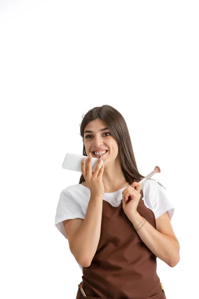 Mulher jovem, visagiste com cosméticos isolados no fundo do estúdio branco — Fotografia de Stock