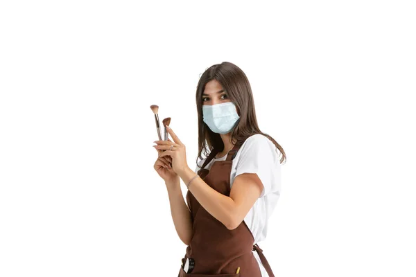 Mujer joven, visagiste con cosméticos aislados sobre fondo blanco del estudio — Foto de Stock