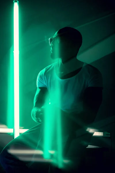 Portret przystojnego młodzieńca w neonowym oświetlonym pomieszczeniu, stylowy muzyk — Zdjęcie stockowe