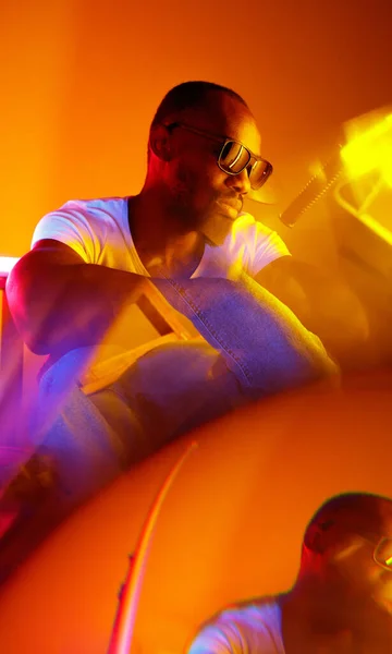 Filmisches Porträt eines gutaussehenden jungen Mannes im neonbeleuchteten Raum, stilvoller Musiker — Stockfoto