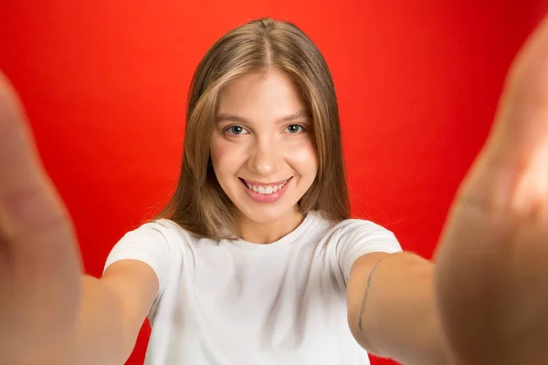 Портрет молодої білої жінки з яскравими емоціями на яскраво-червоному студійному фоні — стокове фото