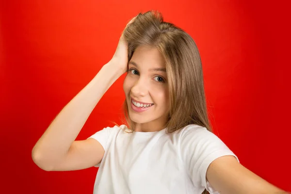 Retrato de jovem caucasiana com emoções brilhantes no fundo do estúdio vermelho brilhante — Fotografia de Stock